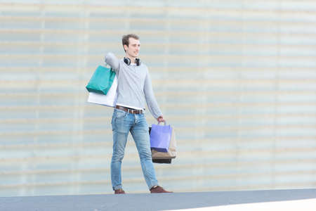 A young handsome man holding shopping bags.の写真素材