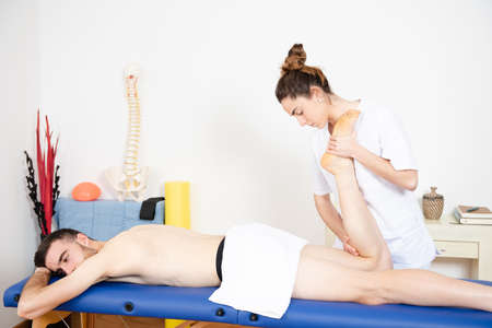 Physiotherapist working on the leg muscles of an athlete.の写真素材