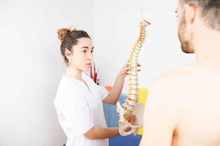 Physiotherapist explaining the spinal column or dorsal spine operation to a patient.の写真素材