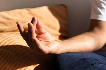 Closeup detail of the hand of hispanic man meditating or making yoga.の写真素材
