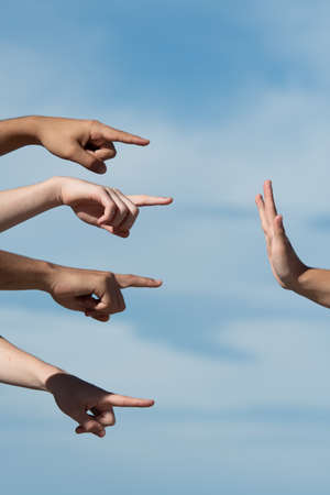 Hands pointing to a person making the stop gesture with the palm. Accusation and guilt concept.の写真素材