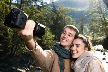 Photographer directing a model in nature, beside a river