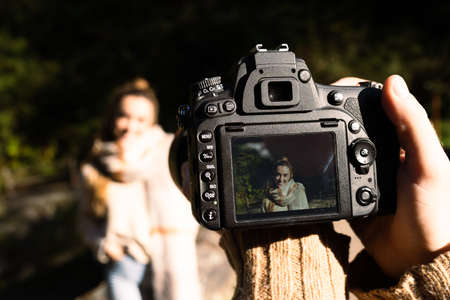 Photographer directing a model in nature, beside a river