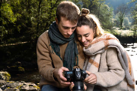 Photographer directing a model in nature, beside a river