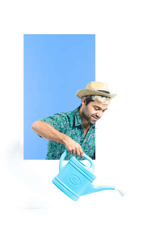 Hispanic hipster holding a springkling can and watering while looking to white copy spaceの写真素材