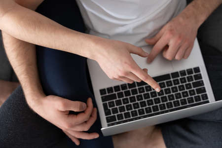 Hands using laptop and pointing to the screen