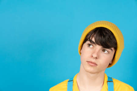 Pensive cute teenager boy looking to copy space. Day dreaming and puberty aspirations conceptの写真素材