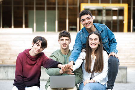 Group of college students together looking at camera and giving high fiveの写真素材