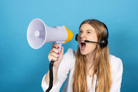 Angry telemarketing worker shouting on megaphone. Virtual assistance operator isolated on blue...