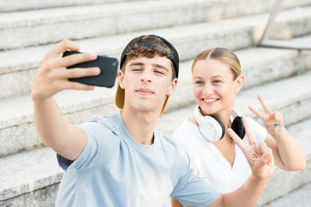 Two friends taking a selfie on stairs.の写真素材