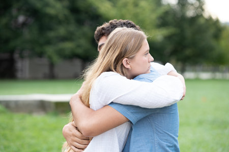 Teenager couple hugging outdoors in a park. Love and support in adolescence conceptの写真素材