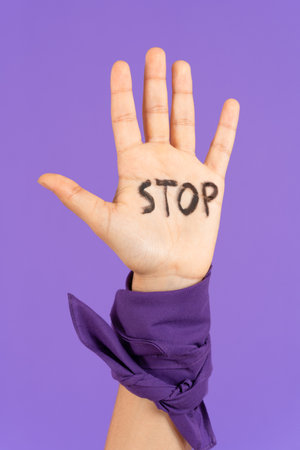 Closeup of stop message on protestor's hand. Feminism, gender violence and equality concept