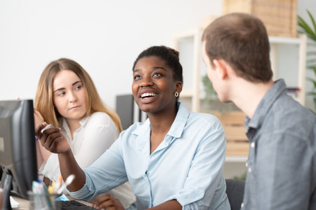 African american woman talking to coworkers in the officeの写真素材