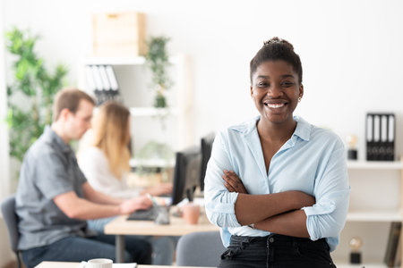 Portrait of young african american woman smiling and looking at camera. Positive leader in the office.の写真素材