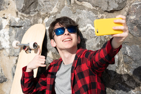 Cool teenager boy taking selfie outdoors