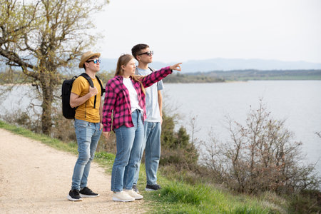 Group of young friends watching the views in nature. Guide showing the park to tourists.の写真素材