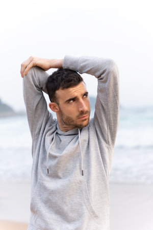 Young sportsman stretching arms outdoors. Athlete warming up before trainingの写真素材