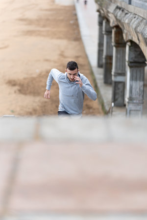 Male runner training on stairs outdoors. Motivation and perseverance concept.