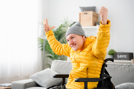 Happy young man with cerebral palsy smiling at homeの写真素材
