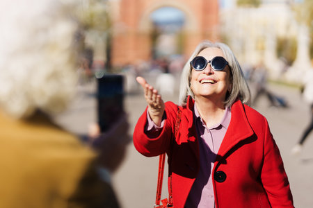 Senior happy woman sending a kiss to camera. Mature cheerful person live streaming on phone