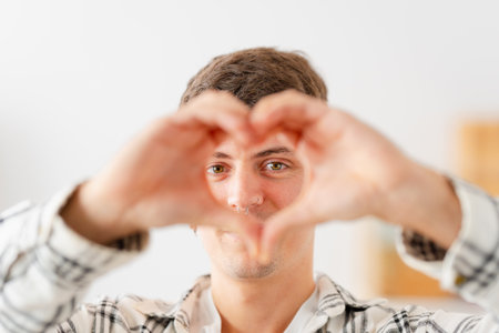 Focus on the face of a man gesturing love with handsの写真素材