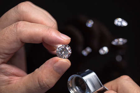 Large polished round cut diamond in hand close up front view. High quality photoの写真素材