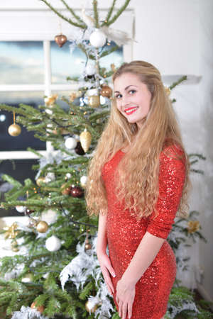 girl standing beside the christmas-treeの写真素材