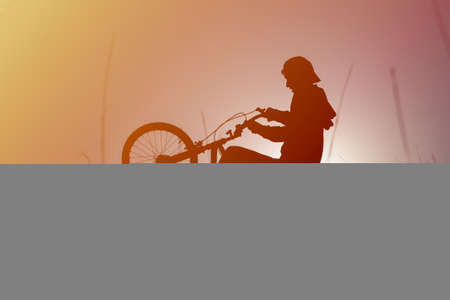 Shadow boy on a bicycle, against the skyの写真素材