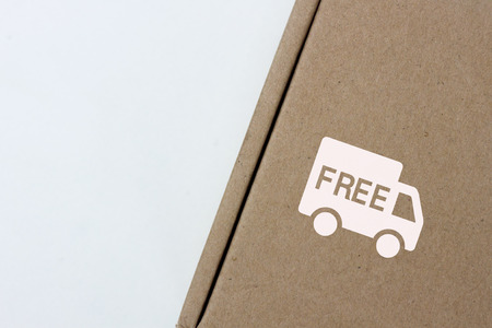 free delivery, business,online shopping, ecommerce and delivery service concept - brown box with note " free delivery " on a gray background. Flat lay, top view.の写真素材