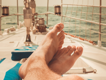 Men's feet on the yacht. Summer time