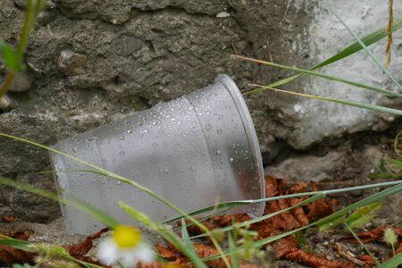 Empty used plastic cup on blurred background. Environmental pollution