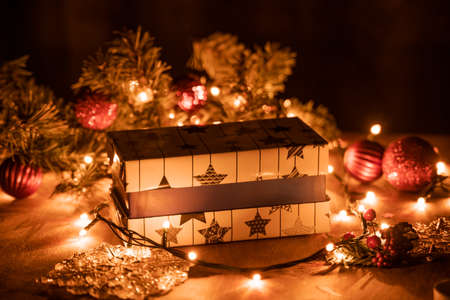 Christmas gift boxes decoration with Christmas tree and candle lights on the wooden table with bokeh lightsの写真素材