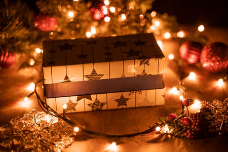 Christmas gift boxes decoration with Christmas tree and candle lights on the wooden table with bokeh lightsの写真素材