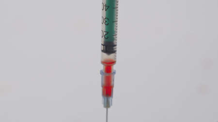 A doctor takes blood from a patient with suspected virus