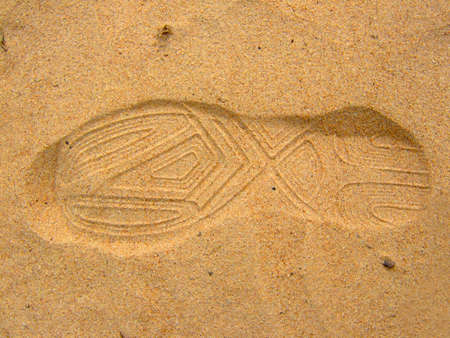 Photo of a trace from a boot on sand.の写真素材