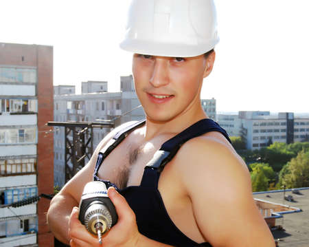 Muscular young man in a builder uniform.の写真素材