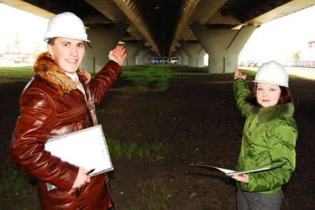 Young architects looking at blueprint. 