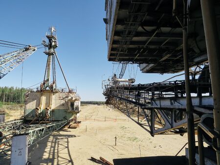 Giant old absetzer rusts in a sand quarry. Huge mining excavator.