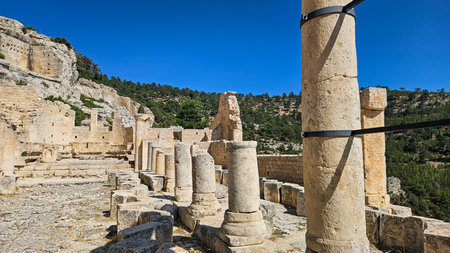 Sunlit Ancient Ruins With Marble Columns And Weathered Temple Remnants Overlooking Olivestudded Valley Terraced Pathways, Carved Capitals, Warm Goldenの写真素材