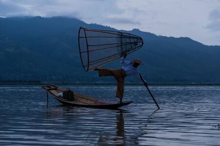 trap fisherman with a boat on Inle Lake in Myanmar at sunriseの写真素材