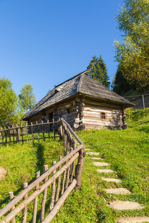 old wooden house in the Carpathian Mountains on a hillside in olruzhenii trees and grassのeditorial素材