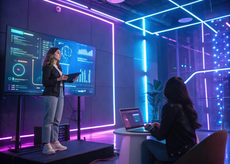Two individuals engage in a data-driven presentation within a sleek, neon-lit room, highlighting a modern and professional environment.の素材