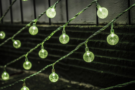 Green Christmas lights hanging on the wall in the city. Vintage style.の素材