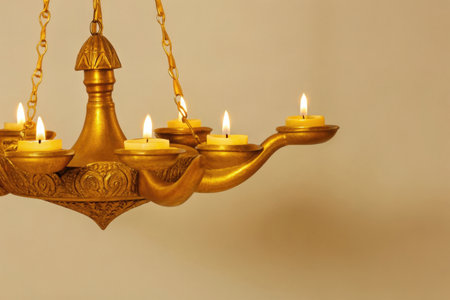 Candles in a brass candlestick on a beige backgroundの素材