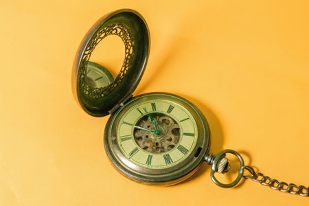Vintage pocket watch on yellow background. Copy space for text.の素材