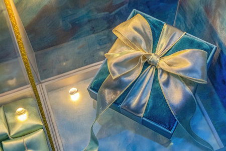 Blue gift box with gold bow on the background of the mirror.の素材
