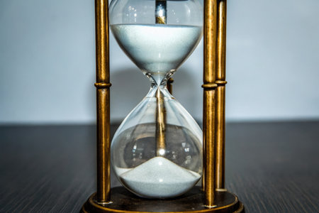 Hourglass on a wooden table, time passing concept of time passingの素材