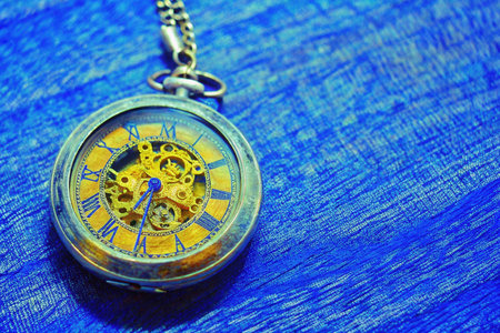 Old pocket watch on a blue background. Time is running out.の素材