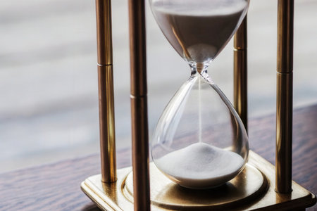 Hourglass with sand on a wooden table. Time management concept.の素材