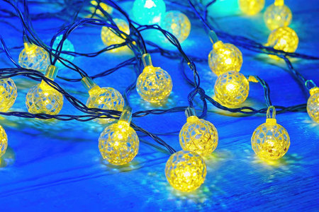 Christmas lights on a blue wooden background. New Year's garlandの素材